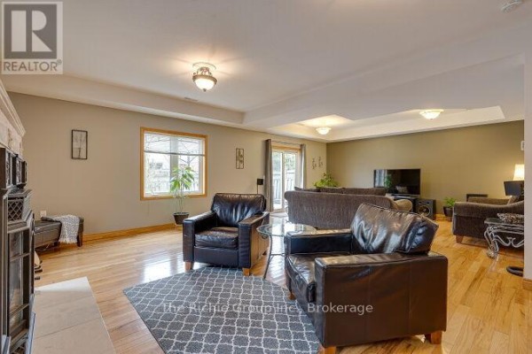 Leather armchairs, sofa, TV, and fireplace in living room - 624 Cedar Street W Shelburne