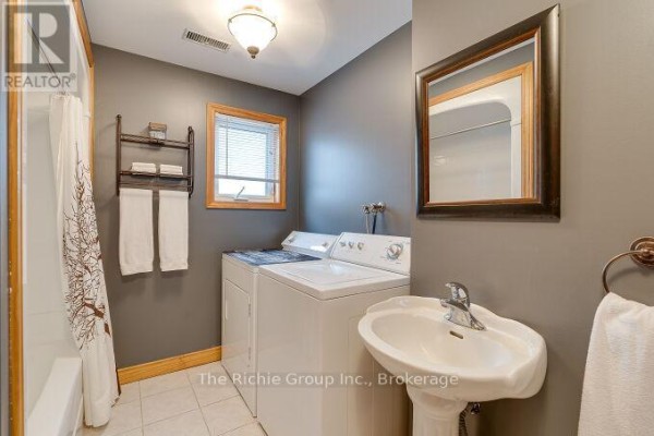 Washing machine, dryer, and pedestal sink in bathroom - 624 Cedar Street W Shelburne