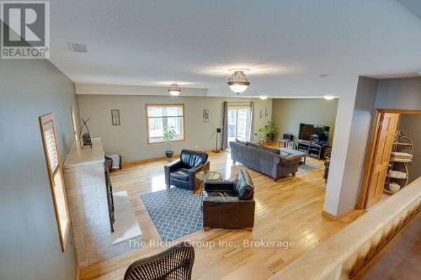 Living room with fireplace, armchairs, sofa, and TV - 624 Cedar Street W Shelburne