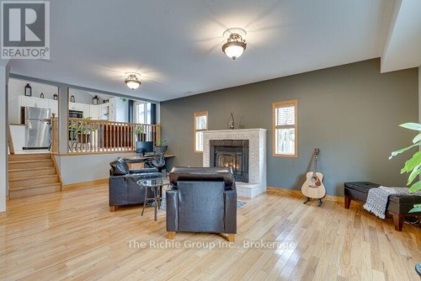 Living room with fireplace, hardwood floors, and kitchen overlook - 624 Cedar Street W Shelburne