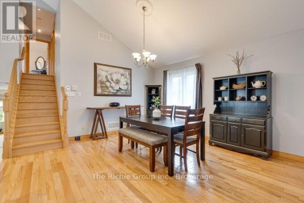 Dining room with hardwood floors, dark dining set, black hutch, and staircase - 624 Cedar Street W Shelburne