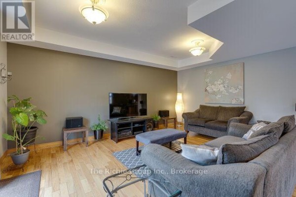 Living room with flat-screen TV, sofa, and artwork - 624 Cedar Street W Shelburne