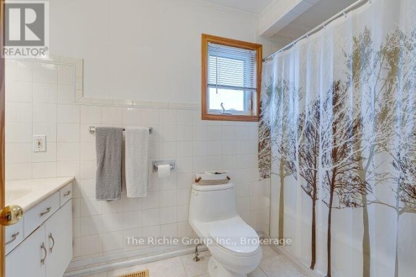 Bathroom with tiled walls, vanity, and tree shower curtain - 624 Cedar Street W Shelburne