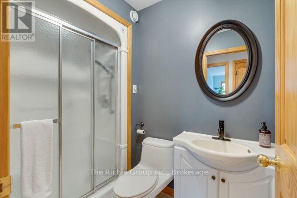Bathroom with sliding shower doors, vanity, and oval mirror - 624 Cedar Street W Shelburne