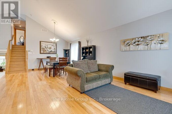 Living and dining area with hardwood floors, vaulted ceiling, and sofa - 624 Cedar Street W Shelburne