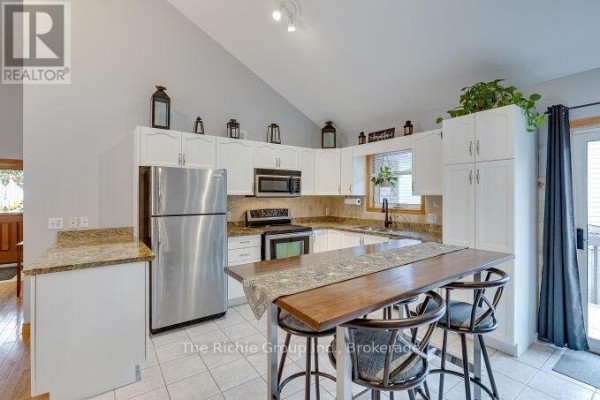 Kitchen with stainless steel appliances, granite counters, and breakfast bar - 624 Cedar Street W Shelburne