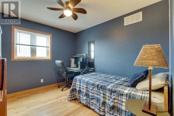 Bedroom with plaid bed, desk, and ceiling fan - 624 Cedar Street W Shelburne