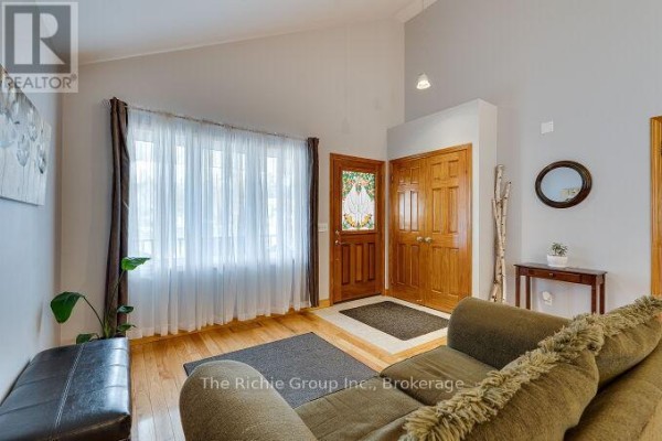 Living room with vaulted ceiling, double entry doors, and large window - 624 Cedar Street W Shelburne