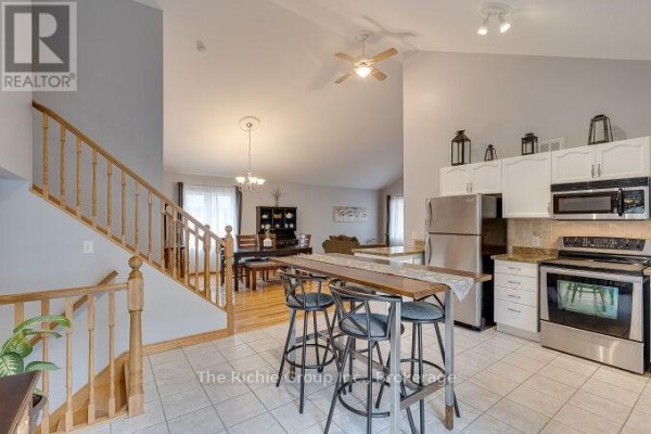 Island kitchen with stainless steel appliances and bar stools - 624 Cedar Street W Shelburne