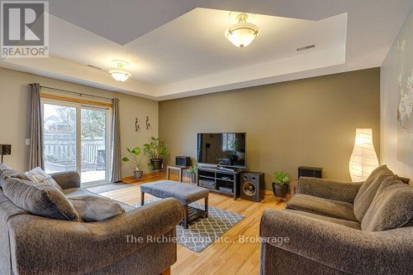 Living room with tray ceiling, sofa, and sliding glass door - 624 Cedar Street W Shelburne