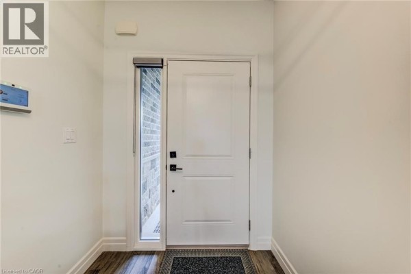 Entranceway with white door, side window, and light grey walls. - 625 Winchester Avenue S, Listowel