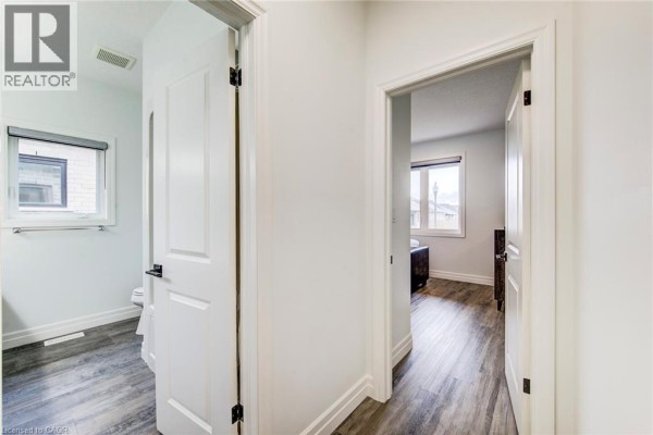 View into a hallway, showing doors to a bathroom and a bedroom. - 625 Winchester Avenue S, Listowel