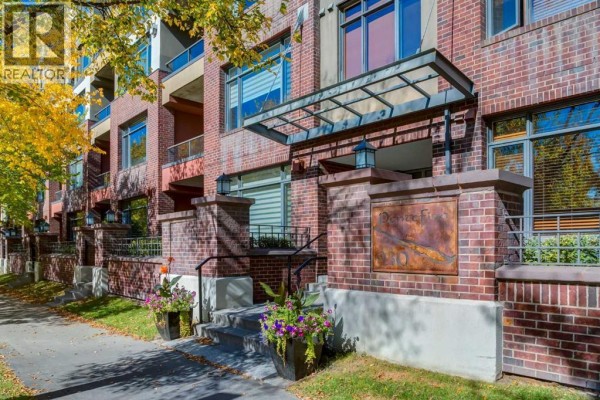 Close-up of the brick exterior and entrance to the apartment building with potted plants. - 626, 930 Centre Avenue Ne, Calgary