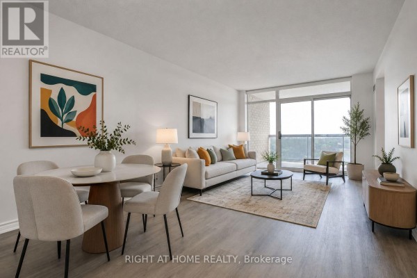 Living and dining area with dining table, sofa, coffee table, and large windows overlooking greenery. - 626 - 18 Mondeo Drive, Toronto