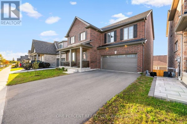 Side exterior of a red brick two-story house with a long paved driveway and neat landscaping. - 626 Haylock Gardens, Peterborough
