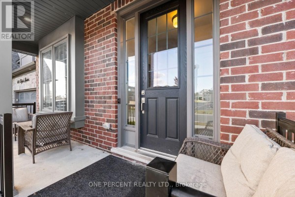 Close-up of the front door and covered porch with wicker seating and a grey doormat. - 626 Haylock Gardens, Peterborough