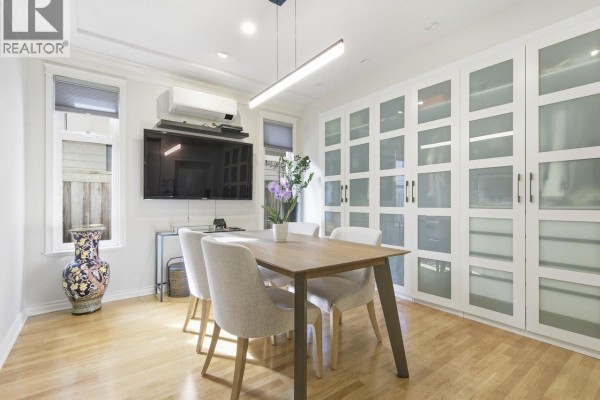 Dining room with hardwood floors, a table and chairs, and extensive frosted glass cabinetry. - 6260 Richards Drive, Richmond