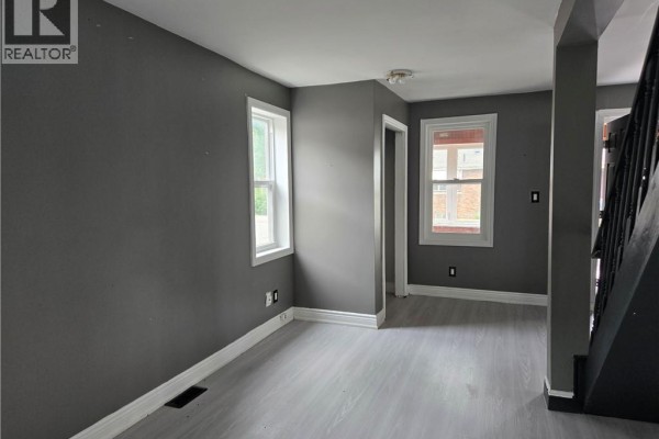 Open-concept living area showing kitchen and living room layout with gray walls and appliances. - 6269 Franklin Avenue, Niagara Falls