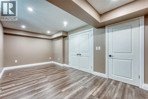 Modern kitchen with large marble island, blue bar stools, and stainless steel appliances - 6275 Disputed Rd. Lasalle