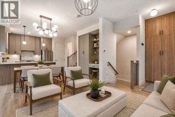 Open concept living and dining area with a kitchen, fireplace, and wood flooring. - 6280 Wales Street, Vancouver