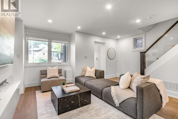 Living room with seating, modern fireplace, and staircase to upper level. - 629 Duplex Avenue, Toronto