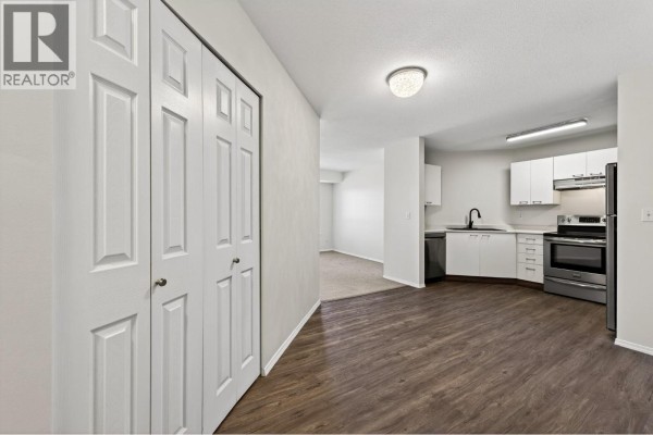 Interior view showing a hallway with white double doors leading to a kitchen and living space. - 629 Lansdowne Street Unit# 605, Kamloops
