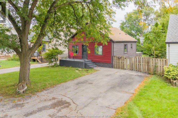 Aerial view of a red clad bungalow with a covered porch and a driveway. - 629 Stanley Street, Windsor