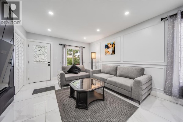 Living room with two gray sofas, a dark gray rug, and a hexagonal coffee table. - 629 Stanley Street, Windsor
