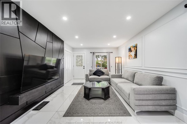 Living room with a large black geometric media unit, two gray sofas, and a dark gray rug. - 629 Stanley Street, Windsor
