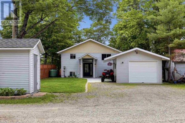 Exterior of a light blue siding house with a detached garage and an ATV parked in the driveway. - 63 Heyden Lake Rd, Aweres
