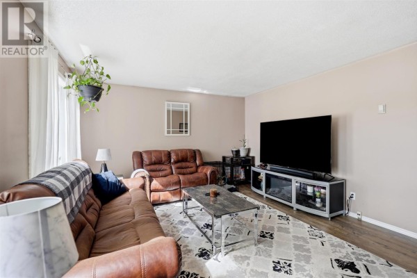 Living room with leather sofas, a television on a media stand, and a large window with lake views. - 63 Heyden Lake Rd, Aweres