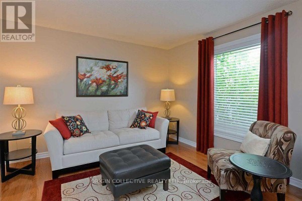 Living room with a white sofa, armchair, ottoman, and red curtains. - 63 Humphrey Drive, Ajax