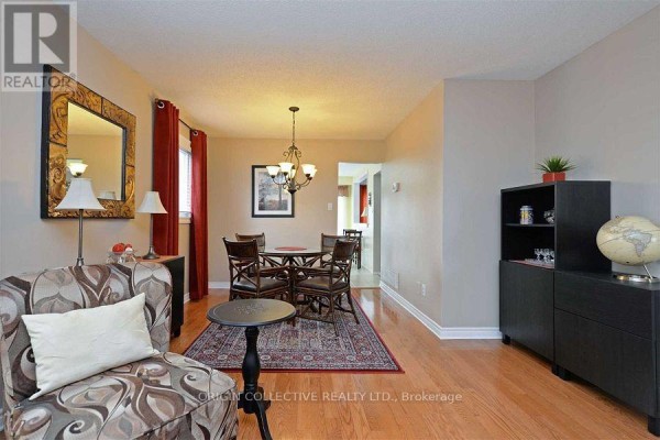 Dining area with a wooden table and chairs, adjacent to the living room. - 63 Humphrey Drive, Ajax