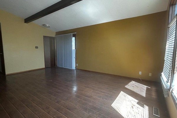 Living room with wood floors, mustard yellow walls, and beamed ceiling. - 63 Main Street, Riverton