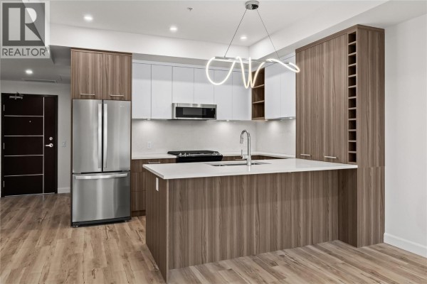 Open-concept space with kitchen and living area, neutral colors and modern finishes - 630 Boynton Place Unit# 305, Kelowna