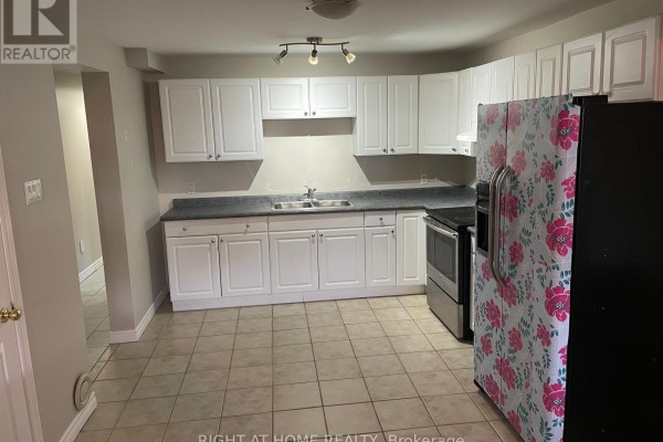 Kitchen with white cabinets, grey countertops, stainless steel appliances, and tiled floor. - 630 Cartier Avenue, Oshawa