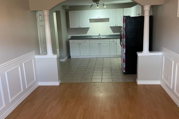 View from a living area with wainscoting into a kitchen with white cabinets. - 630 Cartier Avenue, Oshawa