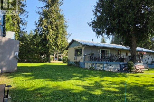 Deck view overlooking river with seating area and decorative statues - 630 Enderby Mabel Lake Road, Enderby