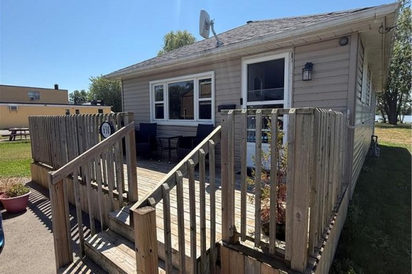 Compact kitchen with white cabinets, green countertops, stainless steel stove, and round table. - 630 Main Street W, Dunnville