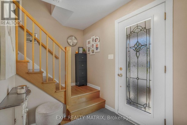 Hallway entrance leading to a kitchen and living area with hardwood floors and tan walls. - 630 Thorne Street, Hawkesbury