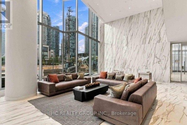 Lobby lounge with large windows offering a city view and leather sofas. - 6305 - 448 Burnhamthorpe Road, Mississauga