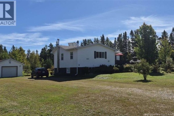 Side exterior view of white sided home with detached garage and treed background. - 631 Gloucester Junction Road, Gloucester Junction