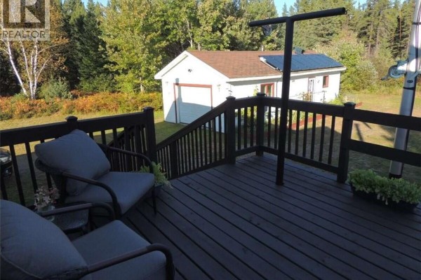 View from deck showing seating area, railing, and detached garage in grassy yard. - 631 Gloucester Junction Road, Gloucester Junction