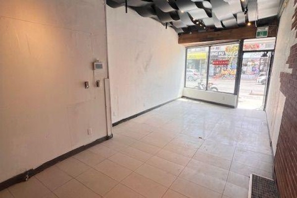 Interior view of a commercial space with white textured walls and exposed brick detail. - 632 Bloor Street W, Toronto