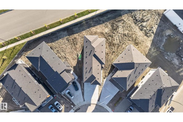 Aerial view of townhouses on a curved street with asphalt roofing. - 6320 24 St Ne Ne, Rural Leduc County