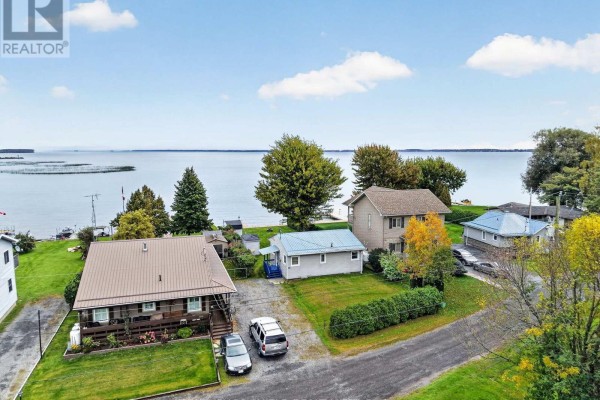 Aerial view shows multiple houses on a waterfront street with a lake in the distance. - 6325 78th Avenue, South Glengarry