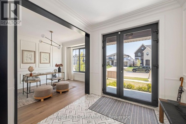 Foyer with glass double doors, leading to a home office with a desk and seating. - 6326 Old Garrison Boulevard, London South