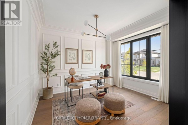 Home office with a wooden desk, modern light fixture, and a large black-framed window. - 6326 Old Garrison Boulevard, London South