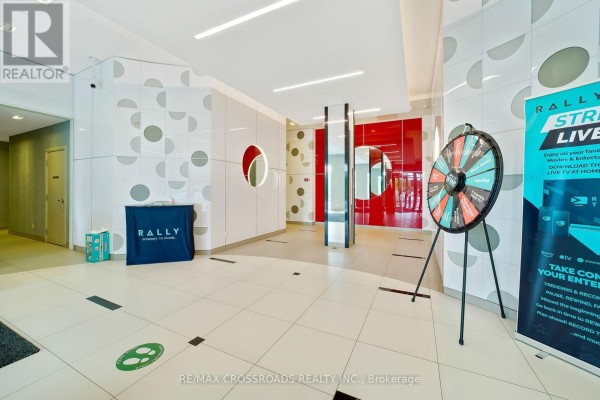 Lobby with patterned walls, seating area, and a prize wheel display. - 633 - 20 Meadowglen Place, Toronto
