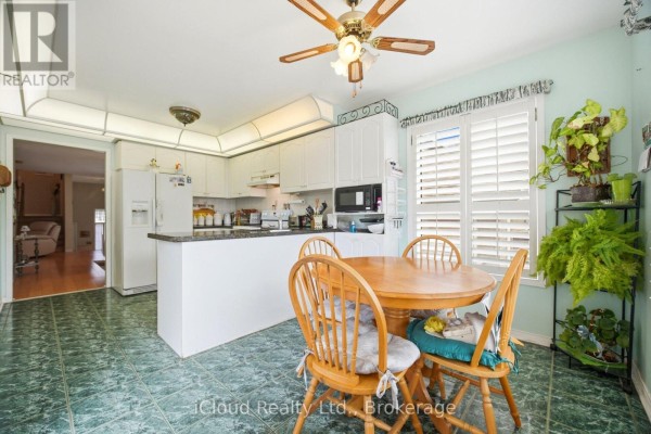Kitchen with dining set, white cabinets, and green tiles - 6332 Glen Meadows Road Mississauga
